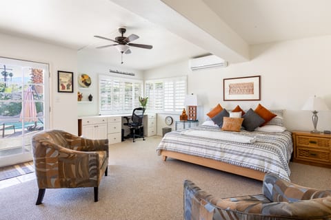 The master bedroom features a king bed, with a built in workspace, and access to the pool.