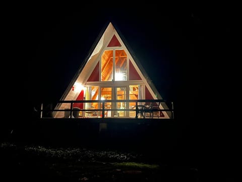 Front of A-frame cabin at night.