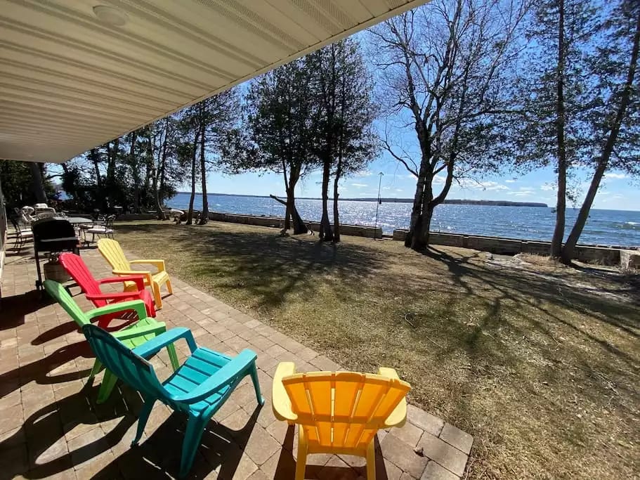Breathtaking views from the massive covered porch overlooking the large yard, fire pit, and waterfront.