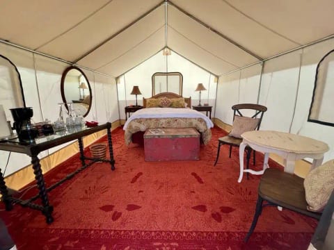 The tent is spacious and cozy with red and gold decorations, beautiful antiques, and a very comfortable queen size bed.