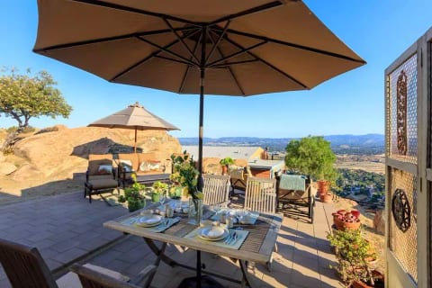 Outdoor table with four chairs and umbrella. Vintage dinnerware service.