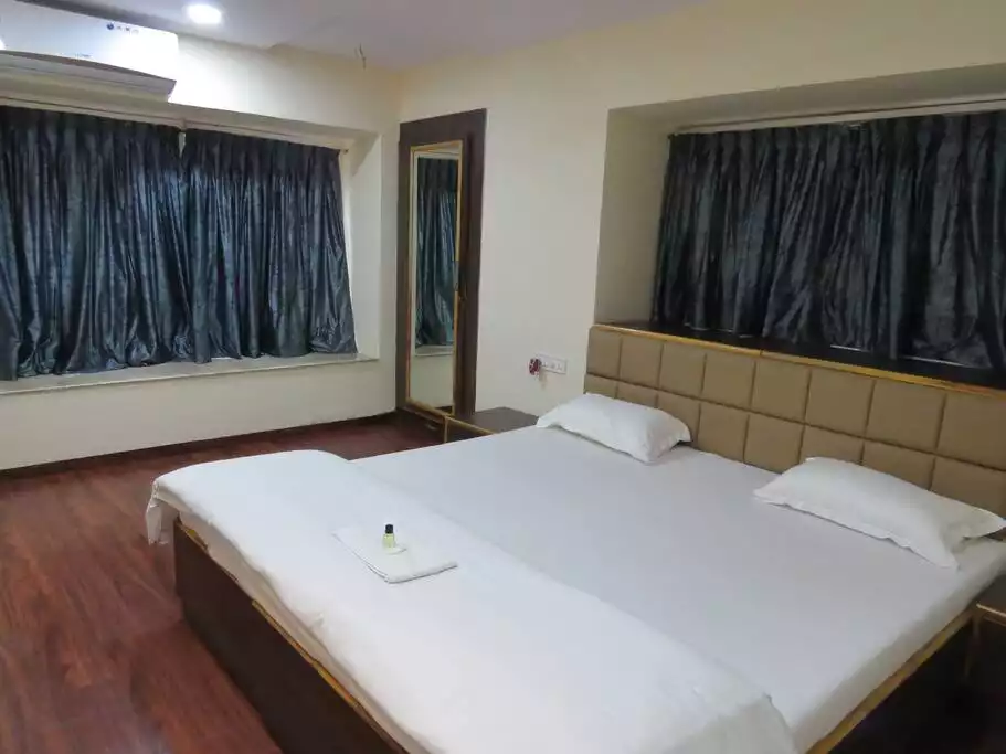Spacious and modern studio aircon room with a king sized bed and concealed wardrobe.