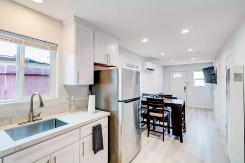 Open Concept Kitchen with Full Fridge/Freezer, Range Stovetop (Stove Only, NO OVEN), Air Conditioning (AC), Dining Table, 55" Wall Mounted Roku TV, Sofa (converts flat to full size bed) and Common Area Half-Bath