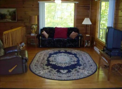 Spacious living area with TV and electric fireplace w/ balcony access.