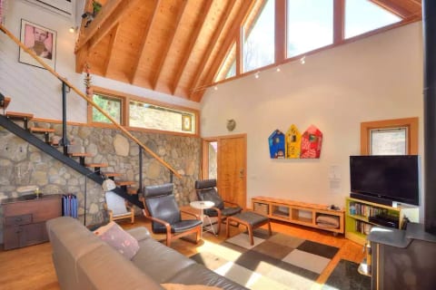 Living room with cathedral ceiling and handcrafted stone walls
