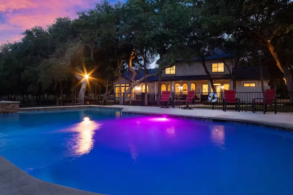 The pool illuminated at night. The pool illuminated at night. - Main House at Whispering Oaks Estate - Dripping Springs