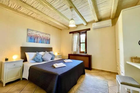 Relaxing main bedroom with king-size bed and air conditioning.