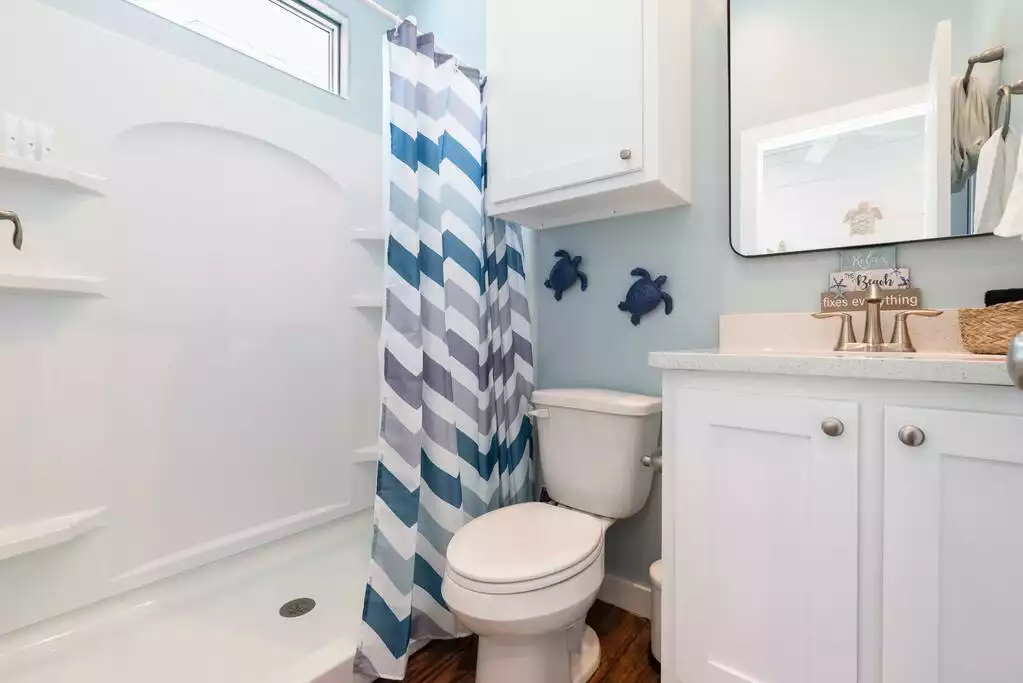 En-suite bathroom in the primary bedroom - Barefoot Bungalow-Brand new, private pool,golfcart - Port Aransas Beach