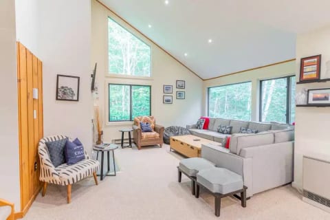 The living room has beautiful woods views. Sofa "feet" pop up for movie lounging