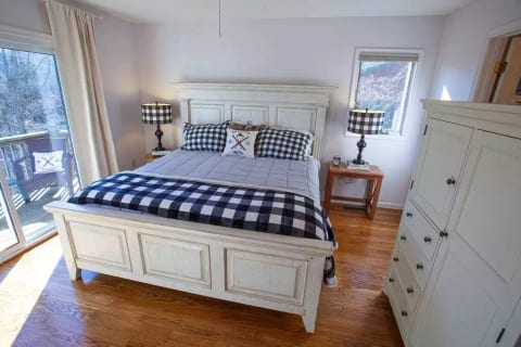 Spacious Master Bedroom (1) on top floor. Has mountain views and deck access. Private ensuite bathroom. TV.