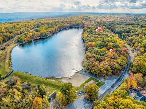 A stunning aerial view of the Poconos, where the lush greenery transforms into a vibrant tapestry of red, orange, and yellow as autumn takes hold.