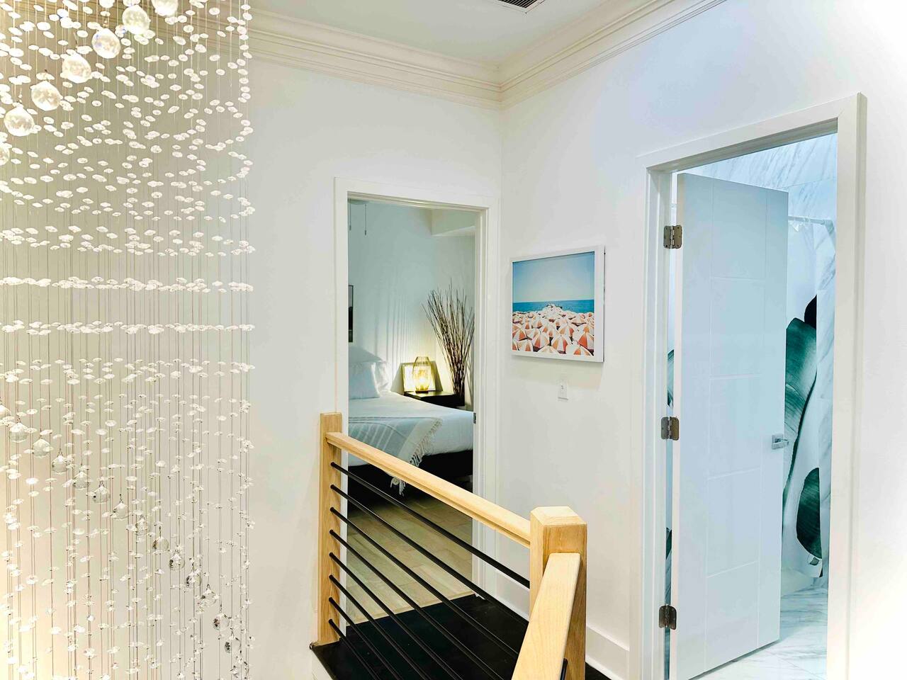 The rainfall chandelier starts on the top floor and falls through the stairwell down into the main floor. From here, you can peek into one of the King bedrooms and a full bathroom. - Miami Escape w/ Pool & Hot Tub - Charlotte