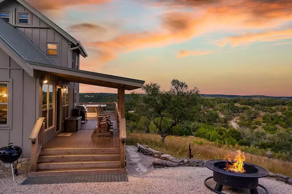 Porch view at sunset on 57 private acres with fire pit, charcoal grill off of deck. - GWR-Private-AmazingHilltopView-HotTub-FirePit-Pool - Fredericksburg