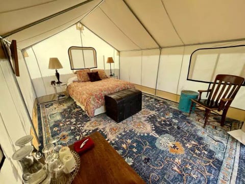 Tent is comfortable and spacious with a queen bed and a place to sit with your morning coffee.