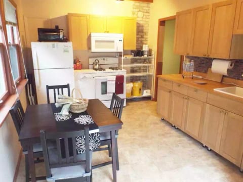 The kitchen is fully equipped with a stove, fridge, microwave, dishwasher, coffee maker, and other small appliances. You'll also find cookware, dishes, cutlery, and spices.