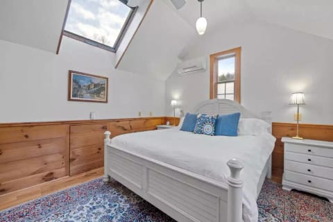 Master bedroom stocked with a tv and king sized bed.