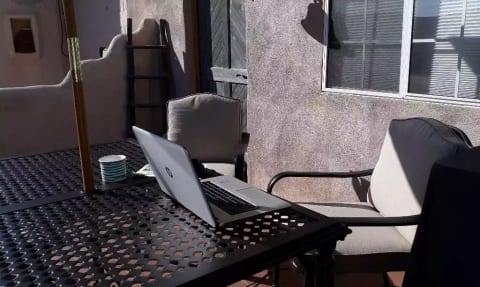 Outside patio with large table, comfortable chairs and BBQ