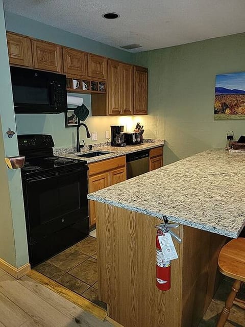 Kitchen with granite countertops, kitchen island, fridge, stove, microwave, dishwasher, toaster, and 2 coffee makers (Keurig and regular)
