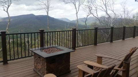 Expansive deck with 10 chairs, gas fire pit, and a picnic table.