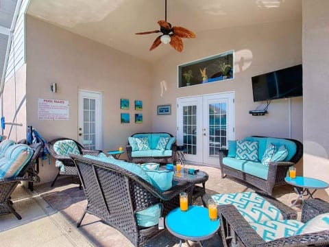 Kick back in the poolside living area with padded rattan seating and 42 inch tv