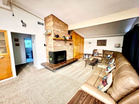 Upper living room with view of hallway to bedrooms and bathroom, kitchen is behind.