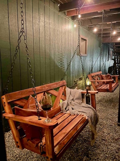 Under balcony swings with string lights. Sit back with a glass of wine at sunset and bask in the beauty of the outdoors