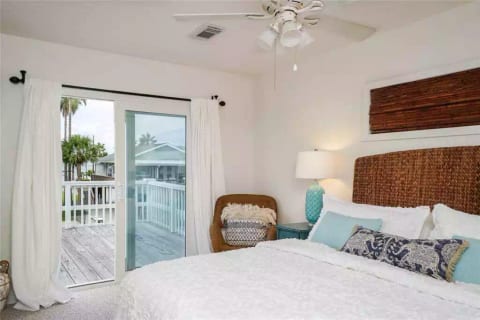 Master bedroom doors open onto the deck with views of the bay and canal. Morning coffee in bed with a view? Yes, please! This spacious bedroom w/ deck access has an en suite bathroom.