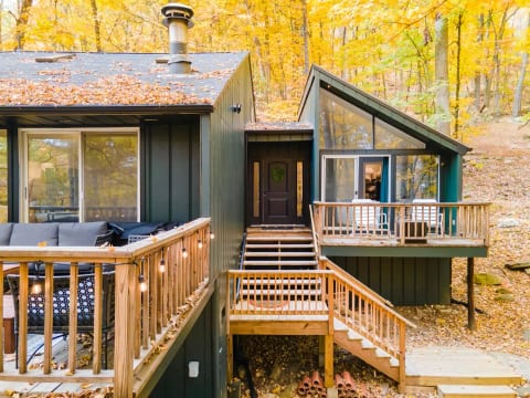 Steps up to the entrance. Bedroom to the right has its own small deck and en suite bathroom. To left, you see the large deck off the great room.