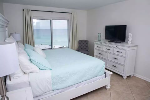 flat screen TV, two night stands, dresser, and chair in master
