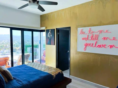 Spa bedroom, sparkle gold wall and light up neon sign perfect for your next IG photo op. Private bath with large steam room, rain shower. Sonos speaker next to the bed & access to the expansive deck, jacuzzi and firepit area.