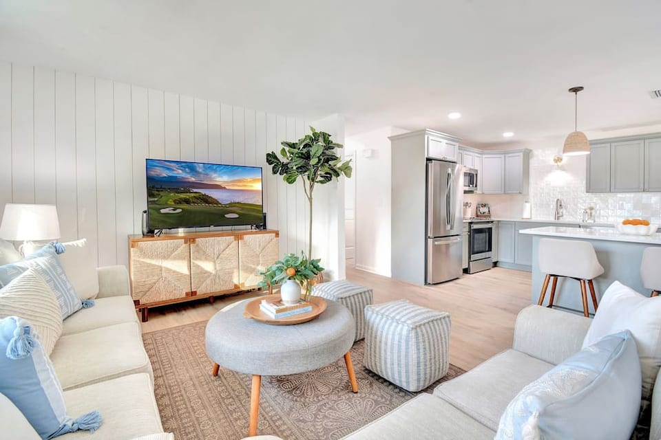 Main living space features an open floor plan with smart TV, comfortable seating and a fully equipped kitchen.