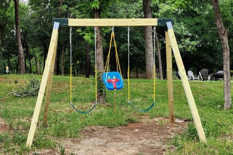 Experience double the fun with our backyard swing! Set against a backdrop of lush greenery and nestled on soft mulch padding, it's the perfect spot for relaxing and enjoying the outdoors with loved ones.