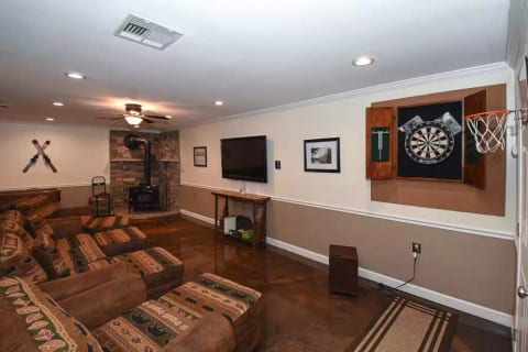Downstairs includes cozy wood burning fireplace, beautifully updated epoxy flooring, Roku TV, gaming console, comfortable seating. Perfect for a movie night!