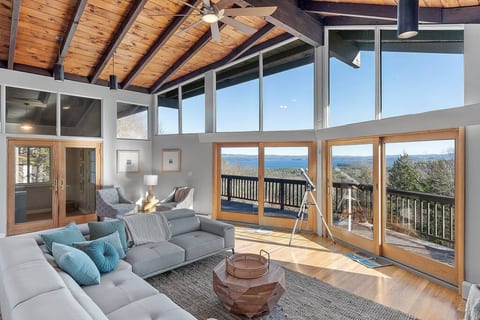 Second Floor living room with Lake and mountain views, 15 feet ceiling, plenty of natural light, and a big deck.