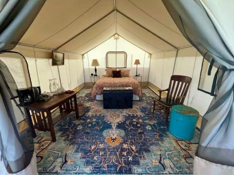 View from the entry way of the Zinnia Glamping Tent. Cozy queen size bed beautiful decorations to keep you feeling cozy and at home.