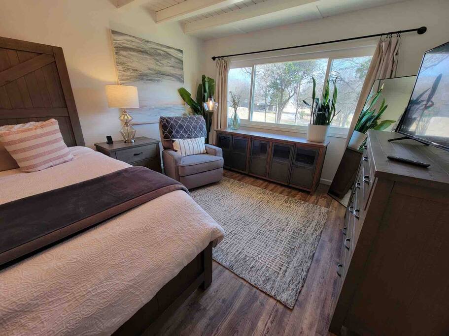 Seating area in master bedroom with comfy velvet recliner for prime tv watching - Magnolia Lakehouse - Clifton