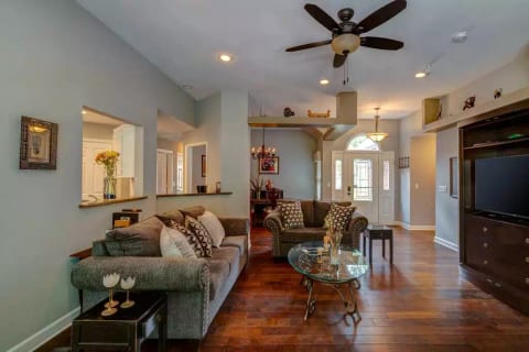 Great room has a large Smart TV, sofa, love seat and cushy chair.